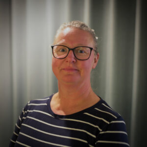 Kvinna som ser in i kameran och ler